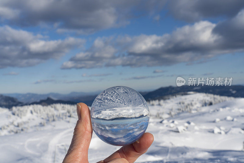 冰冻的冬季景观镜像在镜头球在Velika Planina对蓝色的天空